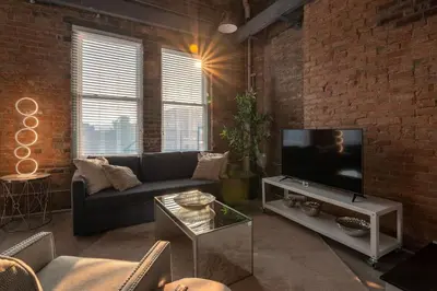 a living room with a couch and a flat screen tv at BUBBLES FANTASY SUITE Explore OTR and Rhinegeist in Cincinnati
