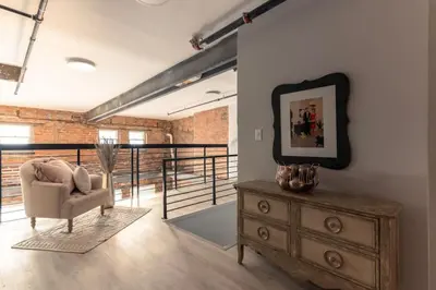 a living room with a dresser and a chair and a mirror at BUBBLES FANTASY SUITE Explore OTR and Rhinegeist in Cincinnati