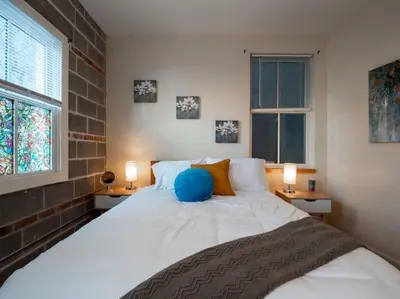 a bedroom with a large white bed with two windows at Luxury Townhome in Heart of Over the Rhine in Cincinnati