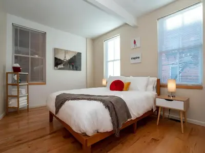 a bedroom with a large bed and two windows at Luxury Townhome in Heart of Over the Rhine in Cincinnati