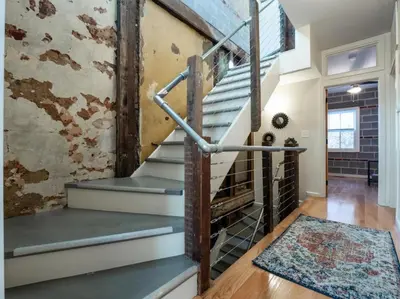 a staircase in a loft with a brick wall at Luxury Townhome in Heart of Over the Rhine in Cincinnati