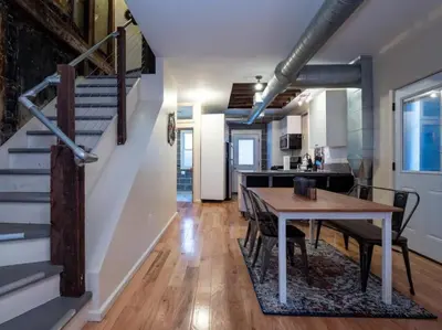 a kitchen and dining room with a table and a staircase at Luxury Townhome in Heart of Over the Rhine in Cincinnati