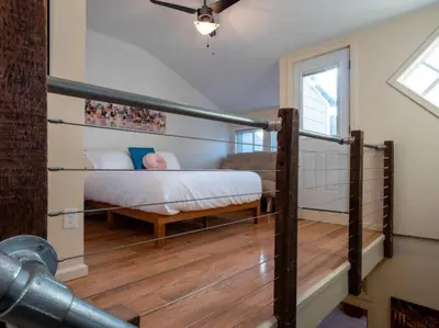 a bedroom with a bed and a stair case at Luxury Townhome in Heart of Over the Rhine in Cincinnati