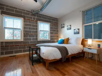 a bedroom with a bed and a brick wall at Spacious Suites in OTR - Findlay Market in Cincinnati