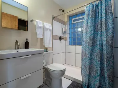 a bathroom with a toilet and a sink and a shower at Spacious Suites in OTR - Findlay Market in Cincinnati