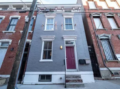 a brick house with a red door on a street at Spacious Suites in OTR - Findlay Market in Cincinnati