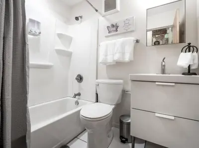 a white bathroom with a toilet and a sink at Spacious Suites in OTR - Findlay Market in Cincinnati