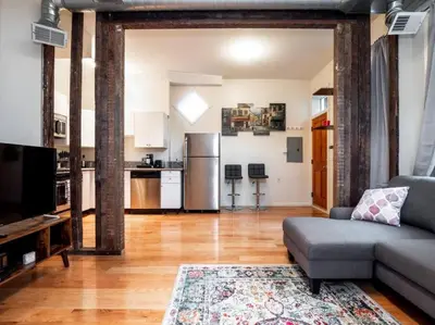 a living room with a couch and a kitchen at Spacious Suites in OTR - Findlay Market in Cincinnati