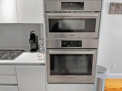 three ovens in a kitchen next to a stove at Findlay Suites - Perfect Location Over the Rhine in Cincinnati