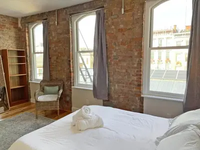 a bedroom with a bed and a brick wall at Findlay Suites - Perfect Location Over the Rhine in Cincinnati