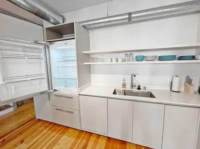 a kitchen with white cabinets and a sink at Findlay Suites - Perfect Location Over the Rhine in Cincinnati