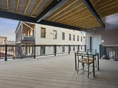 a patio with a table and a chair on a balcony at Findlay Suites - Perfect Location Over the Rhine in Cincinnati