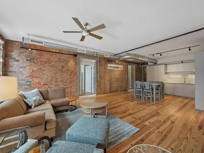 a living room with a couch and a brick wall at Findlay Suites - Perfect Location Over the Rhine in Cincinnati