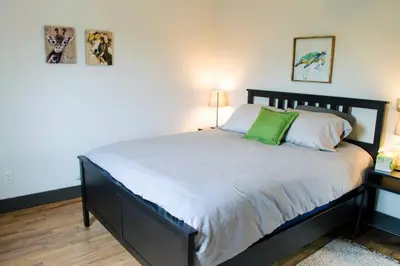 a bedroom with a large bed with a green pillow at Stunning Condos Near Washington Park w Parking in Cincinnati