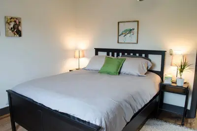 a bedroom with a large bed with green pillows at Stunning Condos Near Washington Park w Parking in Cincinnati