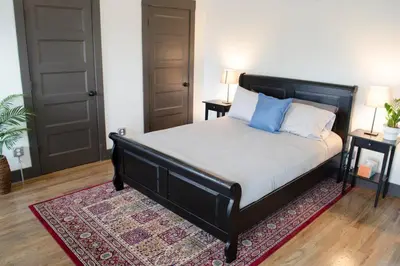 a bedroom with a bed with blue pillows and a rug at Stunning Condos Near Washington Park w Parking in Cincinnati