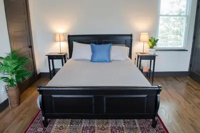 a bedroom with a large black bed with blue pillows at Stunning Condos Near Washington Park w Parking in Cincinnati