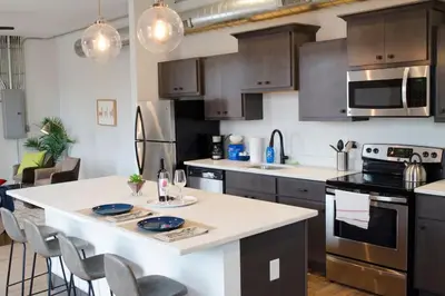 a kitchen with a large white island in a kitchen at Stunning Condos Near Washington Park w Parking in Cincinnati