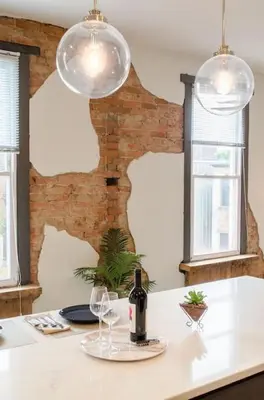 a kitchen with two lights and a table with wine glasses at Stunning Condos Near Washington Park w Parking in Cincinnati