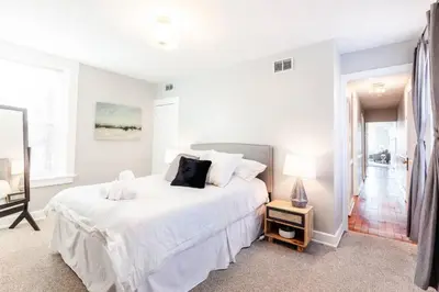 a white bedroom with a large bed with white sheets at Spacious Home Walk to Everything and FREE Parking in Cincinnati