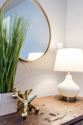 a table with a mirror and a lamp and a plant at OTR Penthouse Walk Everywhere FREE Parking in Cincinnati