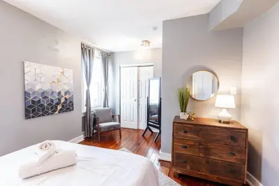 a bedroom with a bed and a dresser and a mirror at OTR Penthouse Walk Everywhere FREE Parking in Cincinnati