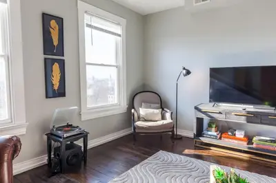 a living room with a flat screen tv and a chair at OTR Penthouse Walk Everywhere FREE Parking in Cincinnati