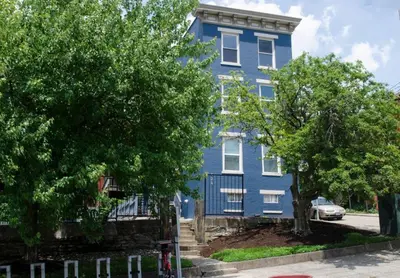 a blue house with trees in front of it at OTR Penthouse Walk Everywhere FREE Parking in Cincinnati