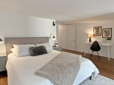 a white bedroom with a large white bed and a table at Explore Downtown and Mount Adams with River Views in Cincinnati