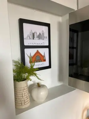 a white vase sitting on a shelf with a plant at Explore Downtown and Mount Adams with River Views in Cincinnati