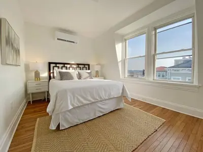 a white bedroom with a large bed and a window at Explore Downtown and Mount Adams with River Views in Cincinnati