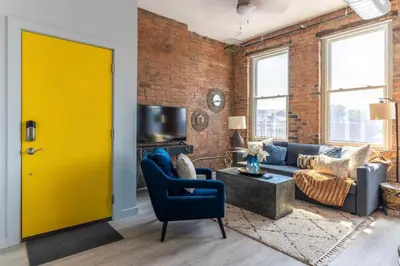 a yellow door in a living room with a brick wall at CHEETAH Venture out on your Cincinnati Safari in Cincinnati