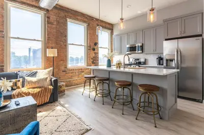 an open kitchen and living room with a brick wall at CHEETAH Venture out on your Cincinnati Safari in Cincinnati