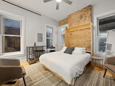 a bedroom with a large bed and a brick wall at Over the Rhine Luxury MicroSuite On Findlay Market in Cincinnati