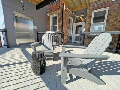 two white chairs sitting on a porch with a trash can at Over the Rhine Luxury MicroSuite On Findlay Market in Cincinnati
