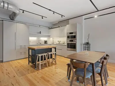 a kitchen with a wooden table and a dining room at Findlay Suites Explore OTR with an Outdoor Deck in Cincinnati