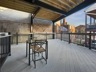 a balcony with a table and a chair on it at Findlay Suites Explore OTR with an Outdoor Deck in Cincinnati