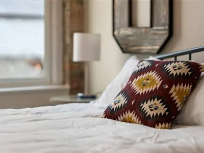 a bed with a pillow on it with a window at Findlay Suites Explore OTR with an Outdoor Deck in Cincinnati