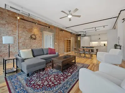 a living room with a couch and a table at Findlay Suites Explore OTR with an Outdoor Deck in Cincinnati