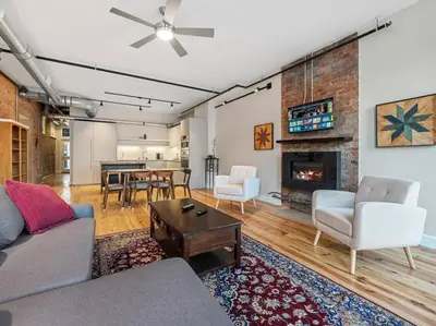 a living room with a couch and a fireplace at Findlay Suites Explore OTR with an Outdoor Deck in Cincinnati