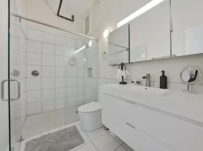 a white bathroom with a sink and a toilet at Findlay Suites Explore OTR with an Outdoor Deck in Cincinnati