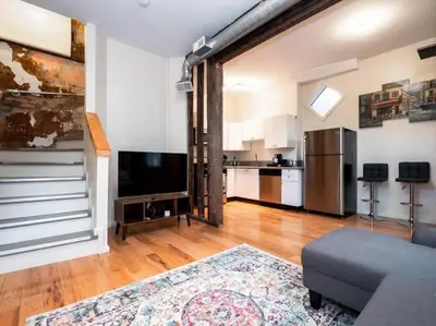 a living room with a couch and a kitchen at Cozy OTR Home with Private Roof Deck in Cincinnati