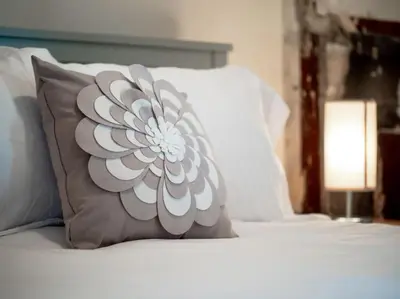 a pillow with a flower on top of a bed at Cozy OTR Home with Private Roof Deck in Cincinnati