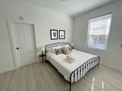 a white bedroom with a bed and a window at Full Building Huge Downtown Retreat Walkable to Everything in Cincinnati
