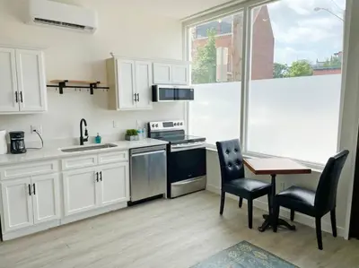 a kitchen with white cabinets and a table and chairs at Full Building Huge Downtown Retreat Walkable to Everything in Cincinnati