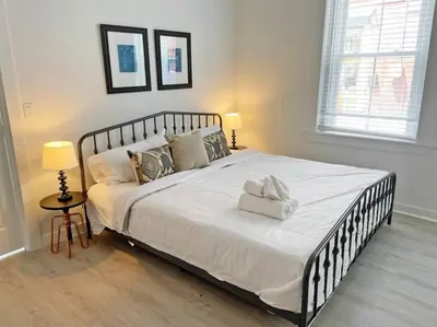 a large white bed in a bedroom with two lamps at Full Building Huge Downtown Retreat Walkable to Everything in Cincinnati