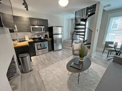 a living room with a couch and a table and a kitchen at Full Building Huge Downtown Retreat Walkable to Everything in Cincinnati