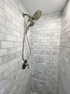 a shower with a shower head on a brick wall at Cute Microapartment Walkable to Everything in Cincinnati