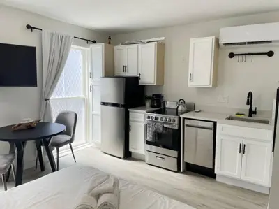 a kitchen with white cabinets and a table and a kitchen with a stove at Cute Microapartment Walkable to Everything in Cincinnati