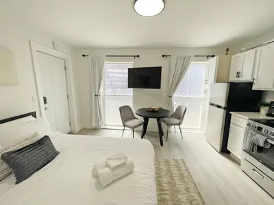 a bedroom with a white bed and a table with chairs at Cute Microapartment Walkable to Everything in Cincinnati